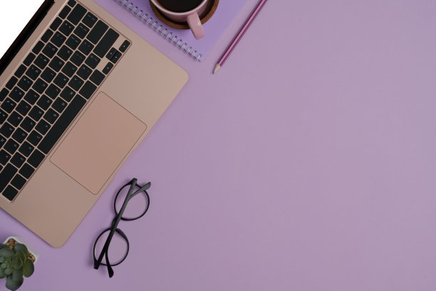笔记本电脑，眼镜，笔记本，肉质植物和咖啡杯紫色的背景与拷贝空间。图片下载