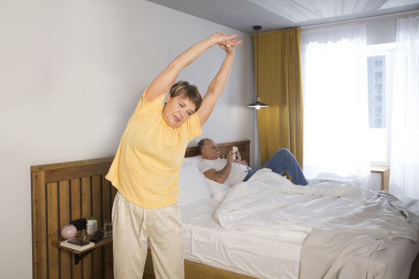 老年夫妇健康的生活方式。早上在家里做运动的老年妇女图片下载
