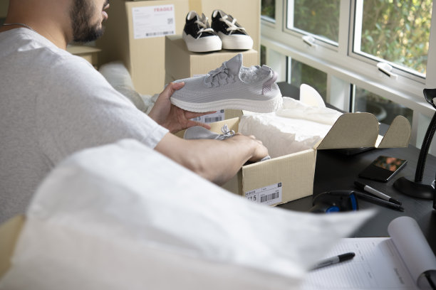 男网上商店小企业主企业家包装包裹邮筒准备送货包裹在桌子上。图片下载