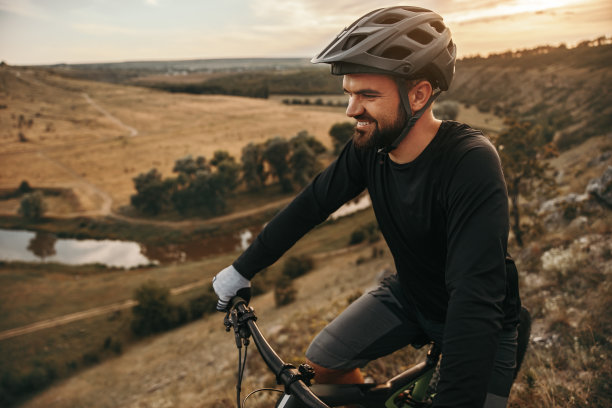 快乐的男自行车手骑自行车在丘陵乡村图片下载