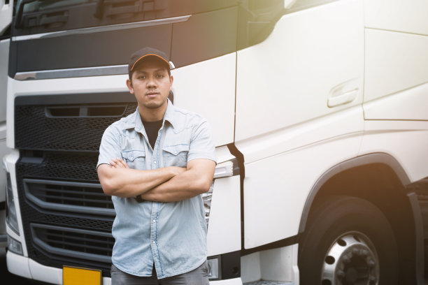 卡车司机与半挂车站在一起。货物运输。货车运输物流。图片下载
