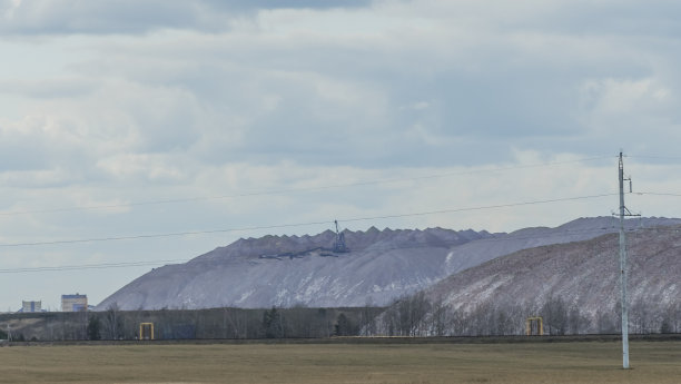 在多云的天空背景下开采钾矿时的空矿山。把一块空石头运到垃圾场。图片下载