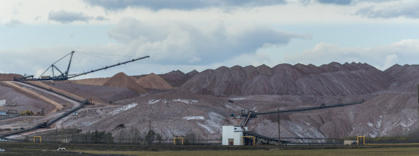 在多云的天空背景下开采钾矿时的空矿山。把一块空石头运到垃圾场。图片下载