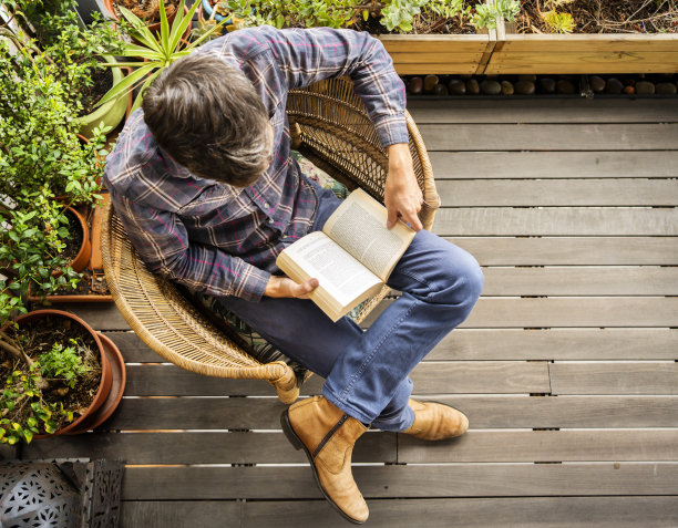 一个年轻人在家里的露台上看书图片下载