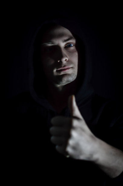 拇指向上-一个年轻的男子肖像帽谁在树荫下用他的手做一个赞成的迹象图片下载