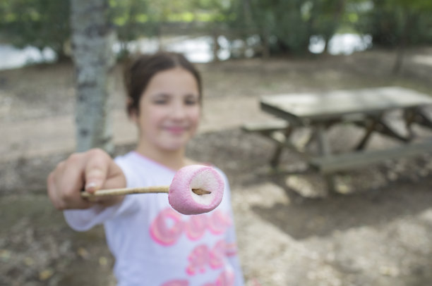 小女孩展示半烤的棉花糖棒图片下载