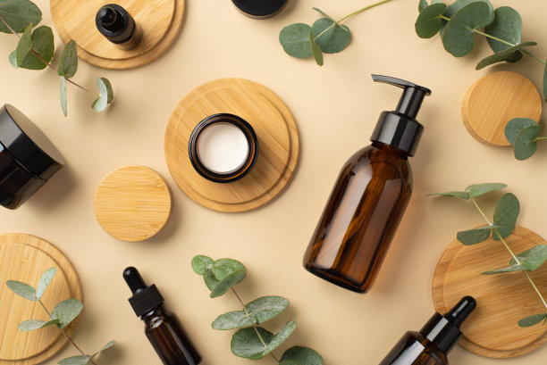 没有塑料的概念。俯视照片的玻璃瓶，奶油瓶，桉树树叶和木站在孤立的米色背景图片下载