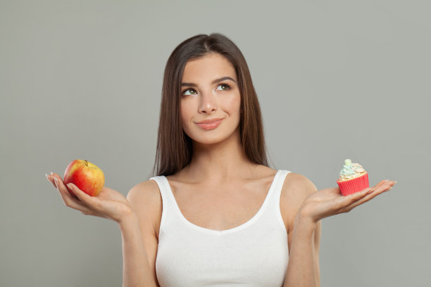 美丽的年轻快乐的女人与苹果水果和糖果。减肥,饮食。节食的概念。健康食品。图片下载