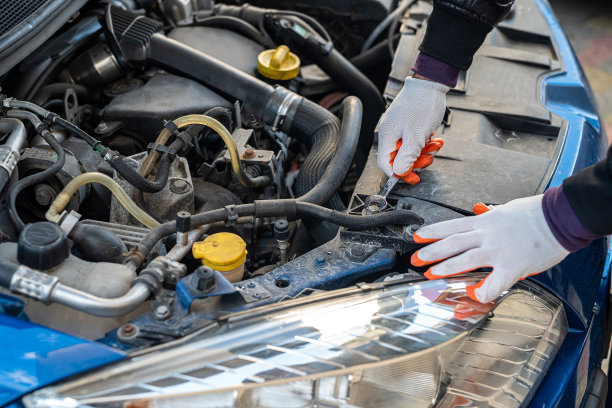 关闭机械师的手握钥匙修理汽车在开放的引擎盖图片下载