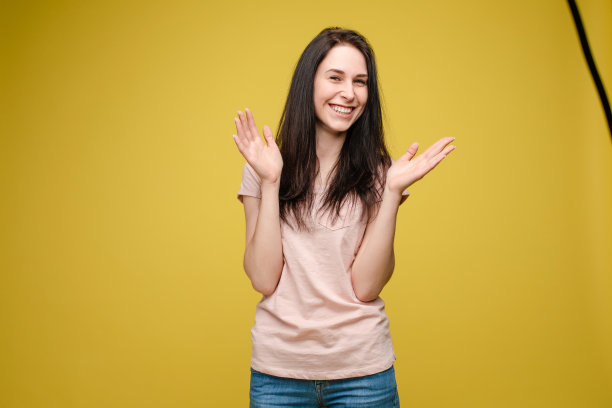 惊讶的年轻女孩在黄色孤立的背景在演播室图片下载