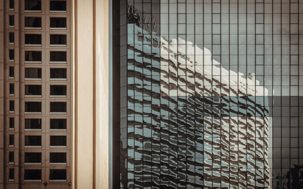 天空和建筑在重复结构建筑的玻璃墙上反射。现代建筑的外部建筑，从外部看，复制空间，选择焦点。图片下载