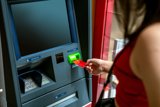 年轻女子在自动取款机上从信用卡中取钱图片下载