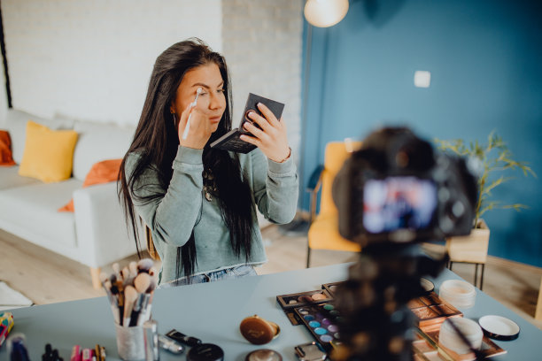 年轻女子在相机上录制化妆教程图片下载