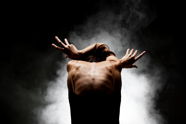 半剪影现代芭蕾舞者摆的黑色背景与烟图片下载