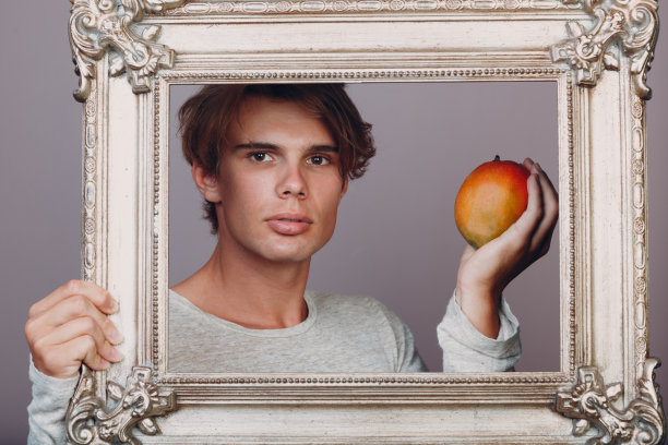 肖像年轻人站在画室与相框。图片下载