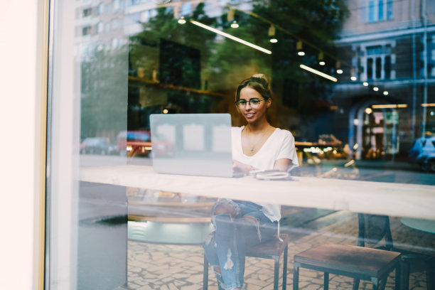 积极的平面设计师，戴着光学眼镜，观看网络研讨会，提高技能，坐在咖啡厅，使用免费wifi连接。开朗的自由撰稿人图片下载