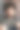 特写严肃英俊的年轻人的脸看着相机坐在椅子上舒适的客厅与砖墙图片下载