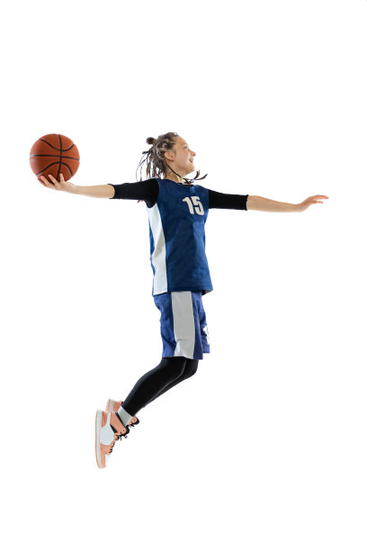 完整长度动态工作室拍摄的年轻女孩，篮球运动员在蓝色制服训练孤立在白色的工作室背景。分开图片下载