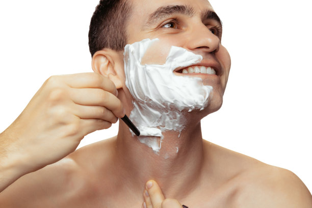 年轻微笑的男子肖像与剃须脸与奶油和剃刀孤立在白色工作室背景。光滑的皮肤图片下载