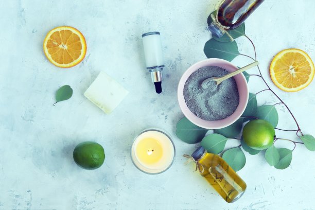 蓝色黏土，磨砂原料，肥皂，桉树叶子和燃烧的蜡烛，放在木桌上，水疗，身体护理图片下载