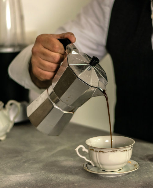 在家里工作的商人，喜欢喝一杯咖啡，在厨房倒咖啡，在笔记本电脑上工作时喝咖啡。图片下载