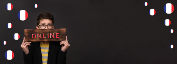 一个英俊的男孩扬言要学法语。木板上的铭文是法语。横幅图片下载