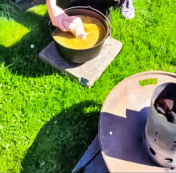 户外荷兰式烤炉烹饪——肉汤里的猪肘和加香料的西红柿图片下载