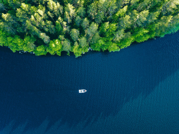 航拍芬兰蓝色湖泊、渔船和绿色森林图片下载