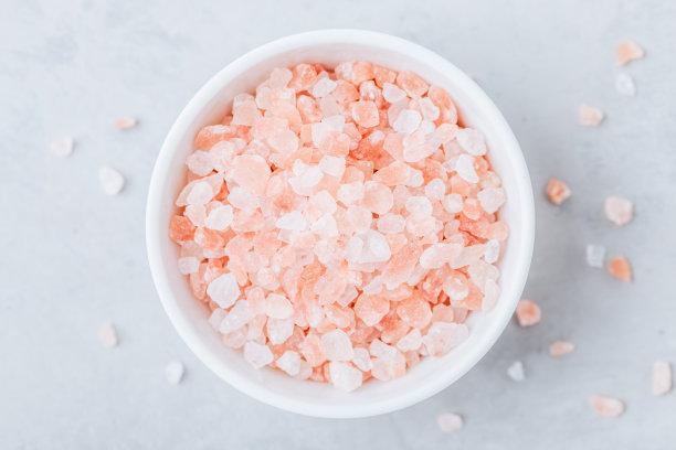 喜马拉雅水晶盐在白色碗灰色的石头背景。图片下载