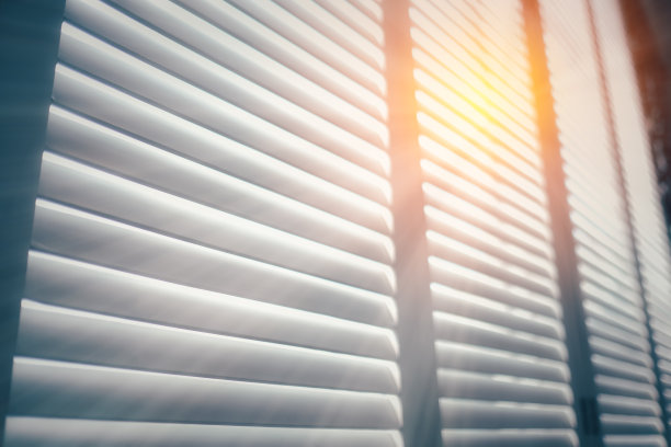 白色木制百叶窗，带有阳光的白色木制百叶窗，复古风格。图片下载