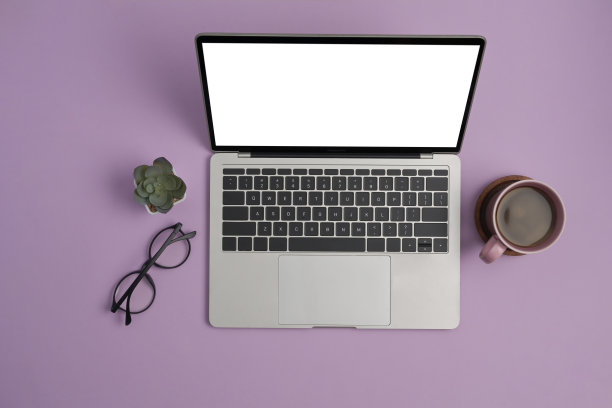 模拟笔记本电脑，眼镜和咖啡杯在紫色的背景。平躺，俯视图。图片下载