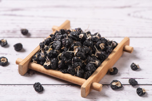 干燥的黑枸杞或黑枸杞浆果放在木桌上图片下载