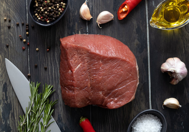 鲜肉里脊配上香草，大蒜，香料放在砧板上。新鲜牛肉肉。高质量的照片图片下载