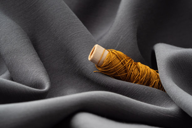 用灰色软布做的铜线线圈，特写，微距。画室，裁缝，缝纫背景。丝质:丝线和缎子织物的纹理时尚设计师，高端时尚理念图片下载