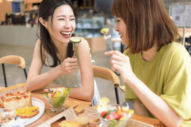 女性朋友在餐厅享受新鲜沙拉，玩得很开心。图片下载