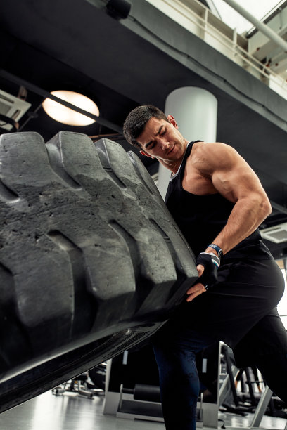肌肉健美男子翻转轮胎。概念功能训练健身房图片下载
