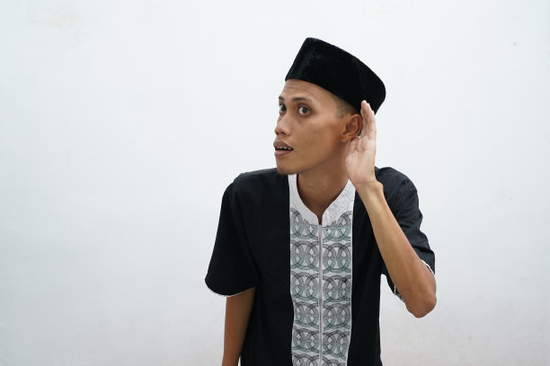 穿着典型阿拉伯服装的亚洲穆斯林男子试图在白色背景上听闲话图片下载