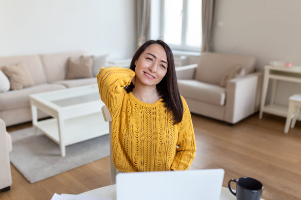 感觉筋疲力尽。沮丧的亚洲妇女看起来疲惫不堪，坐在她的工作地点按摩她的脖子图片下载