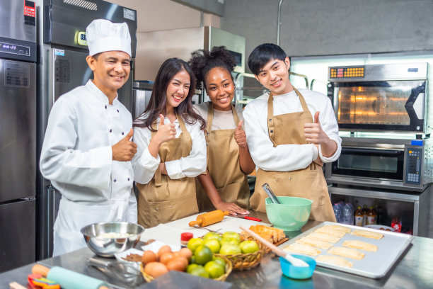 烹饪课的学生在厨房里为食谱混合配料。在厨房烹饪课上，男女青年学生与厨师老师一起准备烹饪材料。图片下载