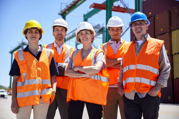 一群戴着安全帽的工程师和货物装卸工人站在货柜码头图片下载
