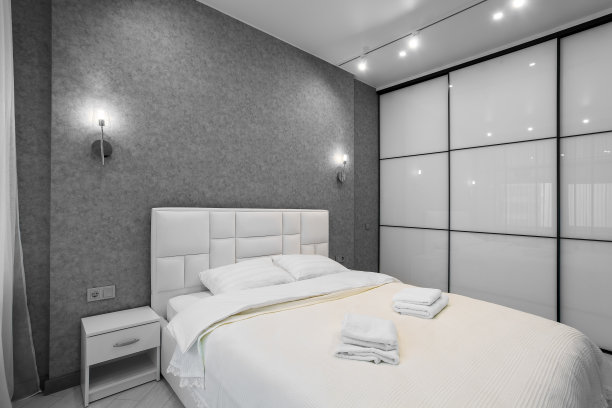 带滑动衣柜和阳台门的主卧室。优雅舒适的酒店卧室内部图片下载