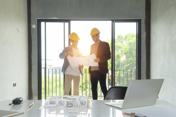 一群工人，一个设计师团队，在施工现场的会议室里交谈，交流，讨论，工作，向同事提出想法。人们的生活方式。公司。男人图片下载