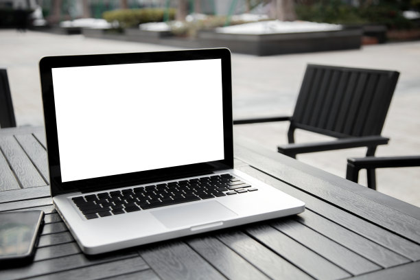 那台黑屏的笔记本电脑放在户外的餐桌上图片下载
