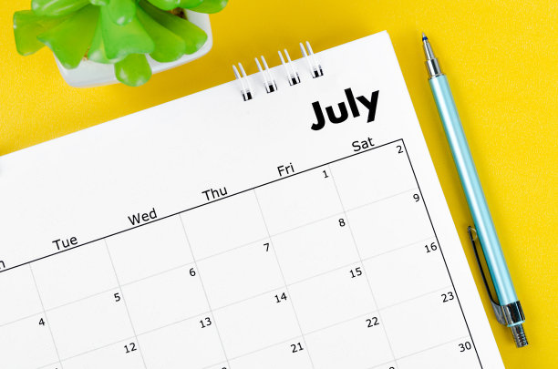 2022年7月黄色底色花盆台历和笔。图片下载