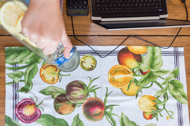 俯视图的女人服务水在一个杯子在桌子上与水果桌布的背景图片下载