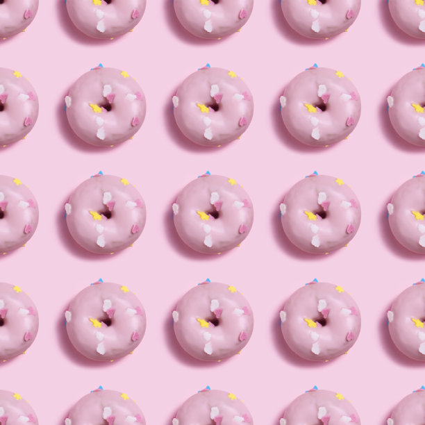 图案无缝的粉红色甜甜圈与粉红色的背景图片下载