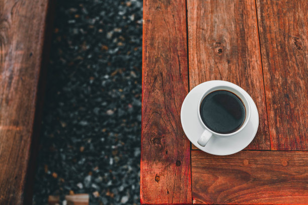 在早晨的阳光下，在木桌上喝一杯咖啡图片下载