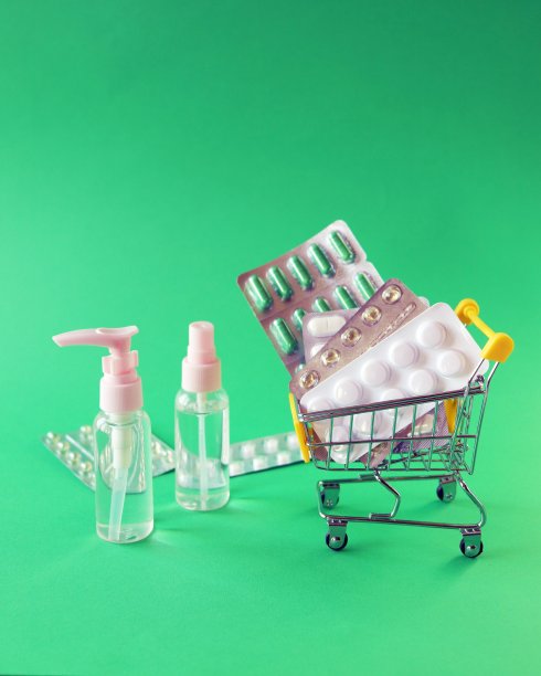 玩具推车上有各种药丸和胶囊，喷在绿色的背景上，有复制空间，药的概念，药房图片下载