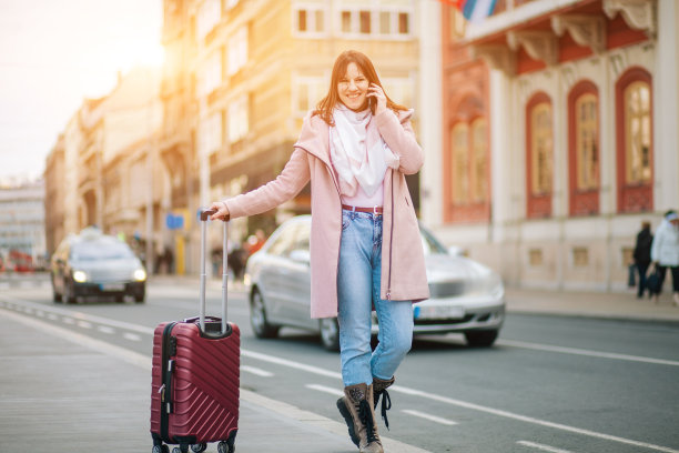 年轻的女游客走手提箱和看向别处图片下载
