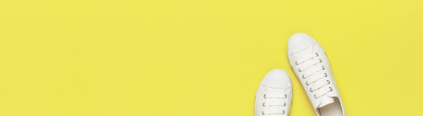 白色女性时尚运动鞋在黄色的背景。平面俯视图拷贝空间。女性的鞋子。时尚的白色运动鞋。时尚博客或杂志概念。简约的鞋子背景长横幅图片下载